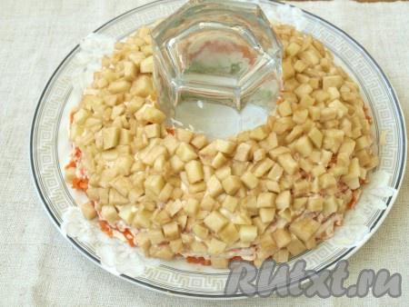 Нарезать кубиками яблоко, очистив его от шкурки, сбрызнуть лимонным соком. Яблоки выложить поверх морковного слоя и тоже смазать майонезом.