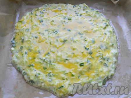 Противень застелить пергаментной бумагой, смазать ее растительным маслом. Выложить кабачковую смесь в виде лепешки, толщиной около 1 см. Смазать желтком (предварительно расколотить вилкой).